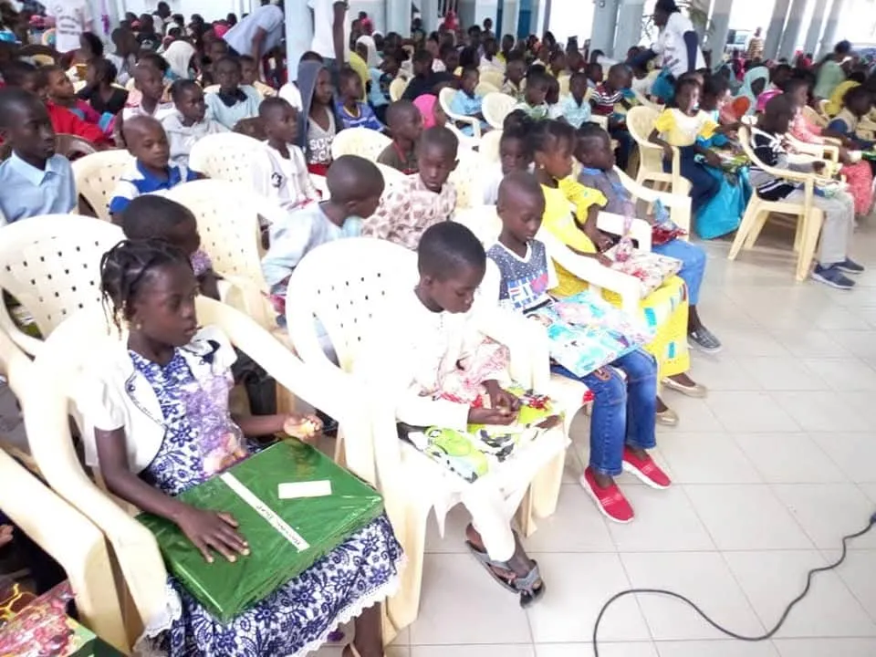 Les enfants assis découvrent leurs cadeaux de Noël
