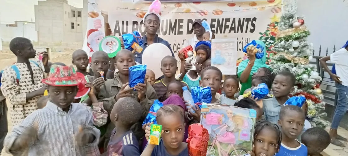 Groupe d’enfants avec leurs cadeaux devant le sapin de Noël