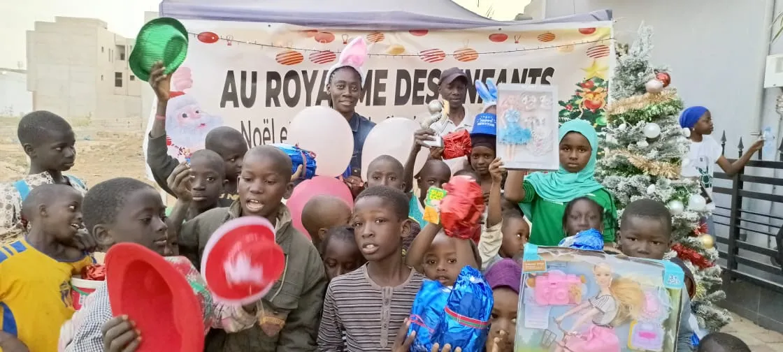 Les enfants rassemblés devant le sapin et la banderole de l’Arbre de Noël