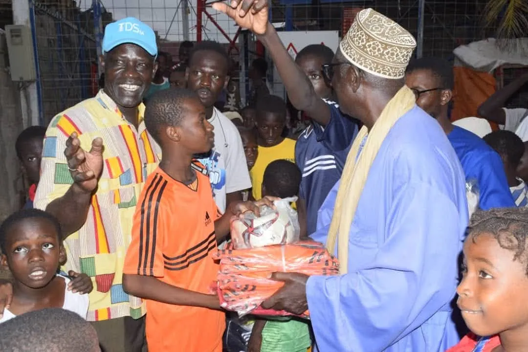Remise de fournitures à un élève lors d’une distribution de quartier